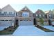 Charming brick townhome featuring attached garages and well-manicured front lawns at 680 Mason Grove Pkwy, Lawrenceville, GA 30043