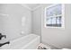 Bright bathroom featuring a white tub with white subway tile surround, window, and dark bronze hardware at 847 Cumberland Ave, Dallas, GA 30157