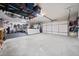 Spacious garage with overhead storage, three garage doors, and epoxied flooring at 847 Cumberland Ave, Dallas, GA 30157