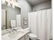 Well-lit bathroom with a marble vanity, framed mirror, and shower with a white curtain at 1377 Village Park Ne Dr, Brookhaven, GA 30319