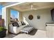 Relaxing covered patio with a comfortable sofa, striped ottoman, and ceiling fan at 1377 Village Park Ne Dr, Brookhaven, GA 30319
