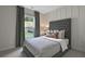 Comfortable bedroom with neutral tones, tufted headboard, and large window offering natural light at 280 Rockledge Sw Bnd, Powder Springs, GA 30127