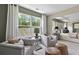 Sitting area with a view into the main bedroom featuring gray chairs, ottomans, and bright windows at 280 Rockledge Sw Bnd, Powder Springs, GA 30127