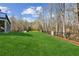 A sprawling backyard featuring lush green grass, mature trees, and manicured landscaping at 4865 Meadow Park Ln, Suwanee, GA 30024