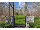 Professionally landscaped backyard with mature trees and lush green grass surrounded by a wrought iron fence at 4865 Meadow Park Ln, Suwanee, GA 30024