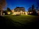 A night shot of the home's backyard featuring a large lawn and a fire pit area at 4865 Meadow Park Ln, Suwanee, GA 30024