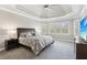 Inviting bedroom with tray ceiling, plush bedding and bright windows at 4865 Meadow Park Ln, Suwanee, GA 30024