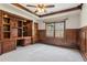 Study featuring custom built-in desk, shelving, wainscoting, and large window at 4865 Meadow Park Ln, Suwanee, GA 30024