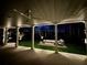 Covered patio with a ceiling fan overlooking a beautifully landscaped backyard and fire pit area at 4865 Meadow Park Ln, Suwanee, GA 30024