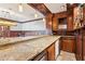 Granite countertop and wooden cabinets complement this stylish wet bar with a sink and a wine cooler at 4865 Meadow Park Ln, Suwanee, GA 30024