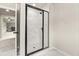 Modern bathroom with marble tile floors and shower with sleek black framed glass doors at 3114 Thicket Ln, Atlanta, GA 30349