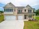 Inviting two-story home boasts a brick facade, three-car garage, and manicured front lawn at 3114 Thicket Ln, Atlanta, GA 30349