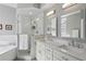 Bright bathroom boasting dual sinks, tile shower with glass door, soaking tub, and modern fixtures at 424 Lindbergh Ne Dr # 201, Atlanta, GA 30305