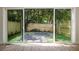 View of the backyard through sliding glass doors with hardwood flooring in the foreground at 622 Bellemeade Nw Ave # 3, Atlanta, GA 30318