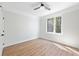 Light and airy bedroom featuring wood floors, a ceiling fan, and a large window overlooking a leafy scene at 622 Bellemeade Nw Ave # 3, Atlanta, GA 30318