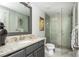 Modern bathroom featuring granite countertop, gray vanity, glass shower, and decorative mirrors creating a spa-like retreat at 219 Dawson Dr, Woodstock, GA 30188