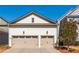 Two-car garage featuring neutral trim, carriage doors, exterior lights and accentuating a well-maintained home at 219 Dawson Dr, Woodstock, GA 30188