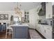 Bright kitchen boasts a center island with marble countertops, stylish lighting, and stainless steel appliances at 219 Dawson Dr, Woodstock, GA 30188