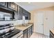 A well-lit kitchen features stainless steel appliances, granite countertops, and dark wood cabinets at 3852 Woodridge Way, Tucker, GA 30084