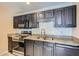 Updated kitchen featuring stainless steel appliances, granite countertops, and dark wood cabinets at 3852 Woodridge Way, Tucker, GA 30084