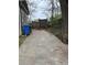 Driveway showing wooden fence, mature tree, trash cans, and the side of the house at 409 Inman Sw St, Atlanta, GA 30310