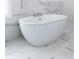 Close-up of freestanding tub with marble tile and a large window at 622 Bellemeade Nw Ave # 4, Atlanta, GA 30318