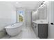 Bright bathroom with dual vanity, freestanding tub, large window, and marble tile at 622 Bellemeade Nw Ave # 4, Atlanta, GA 30318