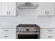 Close-up of a stainless steel oven and stovetop against a white subway tile backsplash at 622 Bellemeade Nw Ave # 4, Atlanta, GA 30318