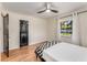 Bright bedroom with hardwood floors, black door, a ceiling fan, and natural light at 1471 Hardin Ave, College Park, GA 30337