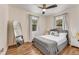 This bright bedroom has a ceiling fan, many windows, a full-length mirror and modern decor at 1471 Hardin Ave, College Park, GA 30337