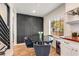 Modern dining area featuring a black round table, gray chairs, and a black accent wall with geometric molding at 1471 Hardin Ave, College Park, GA 30337