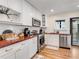 Well-lit kitchen with white cabinetry, stainless steel appliances, and contrasting wooden countertops at 1471 Hardin Ave, College Park, GA 30337