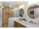 Luxurious bathroom featuring double vanity, elegant fixtures, and a glass-enclosed shower with tile surround at 1667 Grace Se St, Atlanta, GA 30316