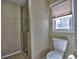 Neutral toned bathroom featuring a glass shower stall, toilet, and window at 2157 Killian Nw Way, Kennesaw, GA 30152