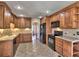 Traditional kitchen with wooden cabinets, tile floors and backsplash, and black appliances at 2157 Killian Nw Way, Kennesaw, GA 30152