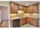Charming kitchen with wooden cabinetry, neutral countertops, tile backsplash, and modern dishwasher at 2157 Killian Nw Way, Kennesaw, GA 30152