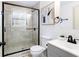 Modern bathroom featuring a glass shower, neutral tiles, and sleek vanity with black hardware at 2177 American Legion Rd, Dacula, GA 30019