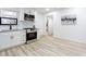 Open kitchen design with white cabinets, stainless appliances, and wood grain flooring at 2177 American Legion Rd, Dacula, GA 30019