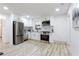 Modern kitchen features white cabinets, stainless steel appliances, and light wood grain flooring at 2177 American Legion Rd, Dacula, GA 30019