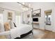 Bright bedroom boasts four-poster bed, modern chandelier, hardwood floors, and a sitting area near the French doors at 11279 Serenbe Ln, Chattahoochee Hills, GA 30268