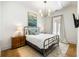 Cozy bedroom features a metal frame bed, wood floors, stylish lighting and decor at 11279 Serenbe Ln, Chattahoochee Hills, GA 30268