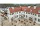 Beautiful European style building with a terracotta roof, white walls, and a courtyard in front at 11279 Serenbe Ln, Chattahoochee Hills, GA 30268