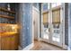 Hallway features blue printed wallpaper, light hardwood flooring, and a glass cabinet at 11279 Serenbe Ln, Chattahoochee Hills, GA 30268