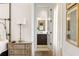 Hallway view into a tastefully designed bathroom from a bedroom with hardwood floors and neutral walls at 11279 Serenbe Ln, Chattahoochee Hills, GA 30268