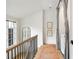 Hallway with a laundry area featuring a curtain, along with a staircase and hardwood floors at 11279 Serenbe Ln, Chattahoochee Hills, GA 30268