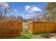 Backyard view through a gate, with artificial turf and fence with hanging lights at 1921 Harrison Park Dr, Atlanta, GA 30341