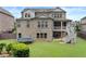 Back exterior view of the home showcasing a brick facade, covered porch and a grassy lawn with a trampoline at 3286 Sweetleaf Ln, Buford, GA 30519