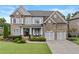 Charming brick home with a well-manicured lawn and a welcoming front porch and two-car garage at 3286 Sweetleaf Ln, Buford, GA 30519