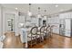 Open kitchen with an island, white cabinets, stainless steel appliances and hardwood floors at 3286 Sweetleaf Ln, Buford, GA 30519