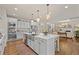 Bright, modern kitchen with white cabinets, stainless steel appliances, quartz countertops, and a large island at 3286 Sweetleaf Ln, Buford, GA 30519
